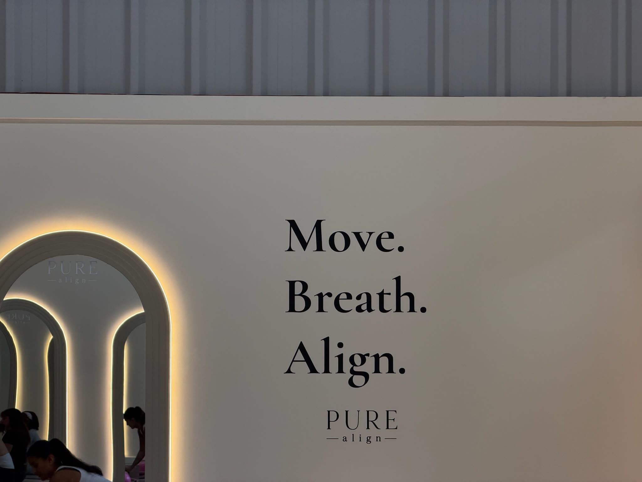 The Move. Breath. Align. wall beside a softly lit arch mirror