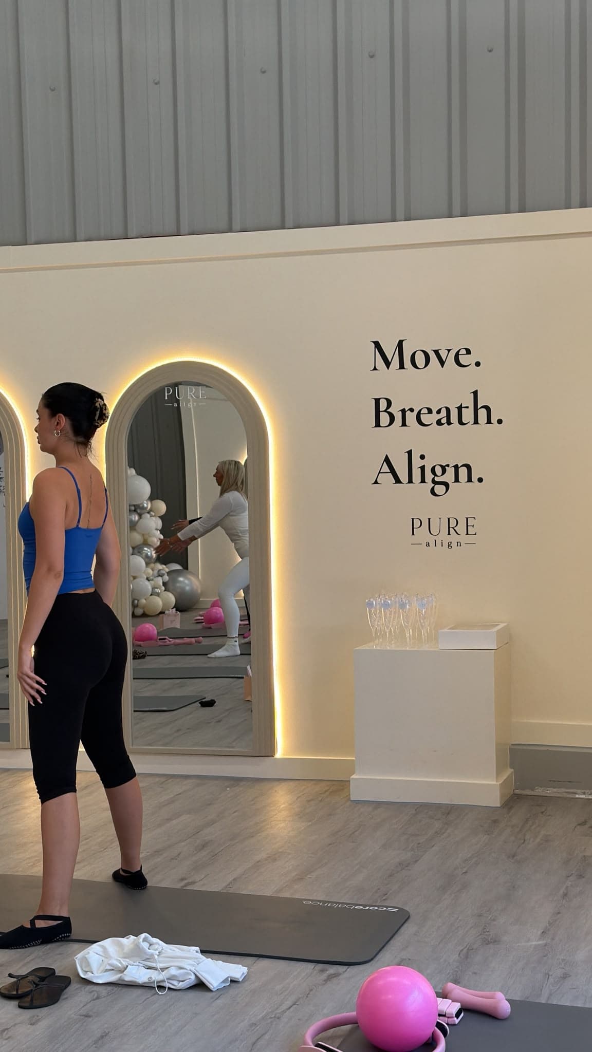 The Move. Breath. Align. quote wall beside the arched mirrors at Pure Align Studios